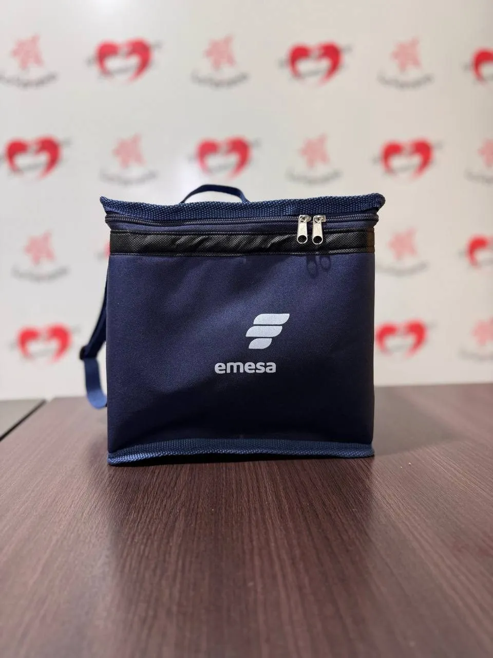 Lonchera térmica azul marino con cierre superior y logo impreso en blanco