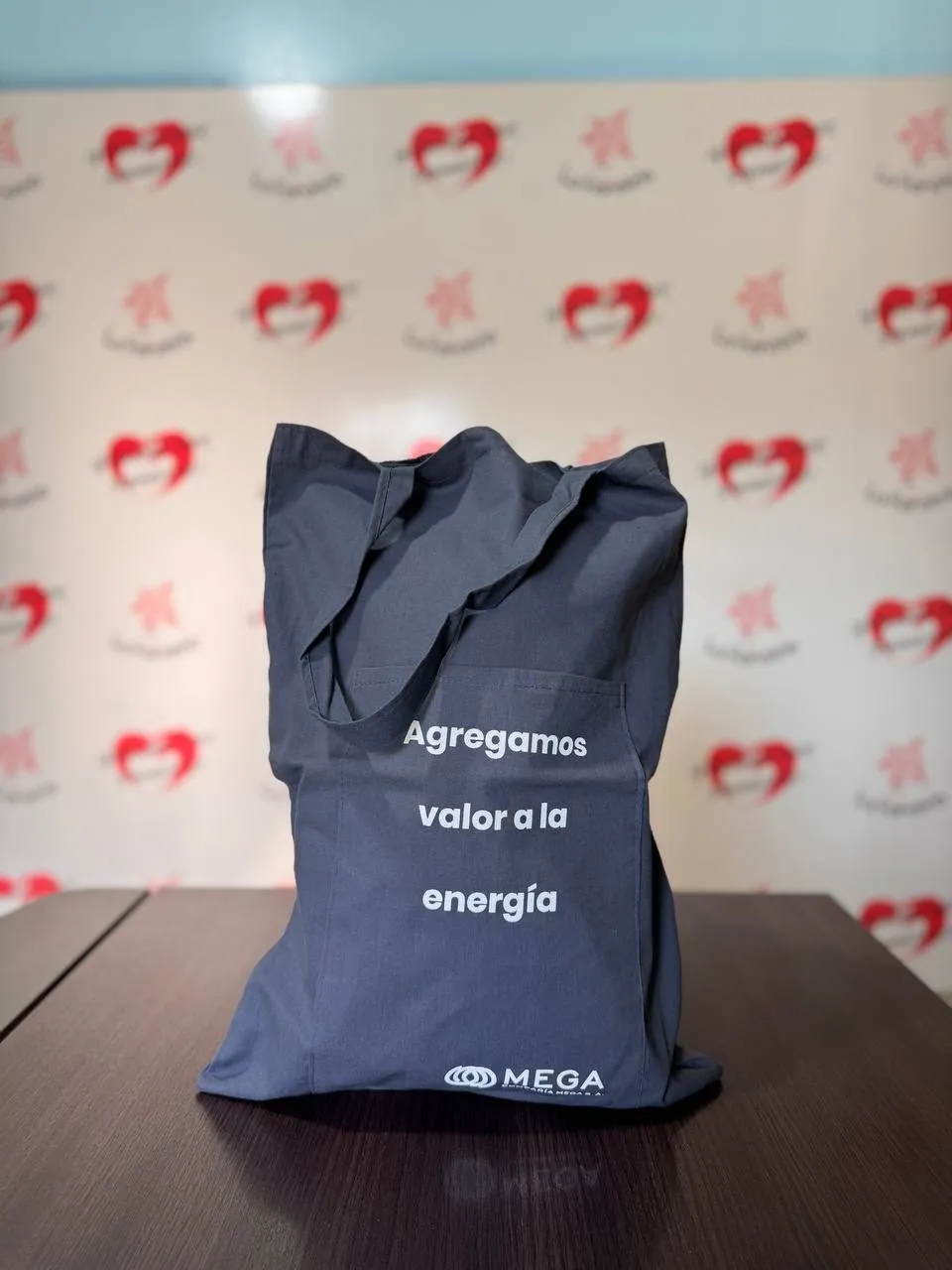 Bolsa de brin en tono gris con asas largas y texto impreso en blanco