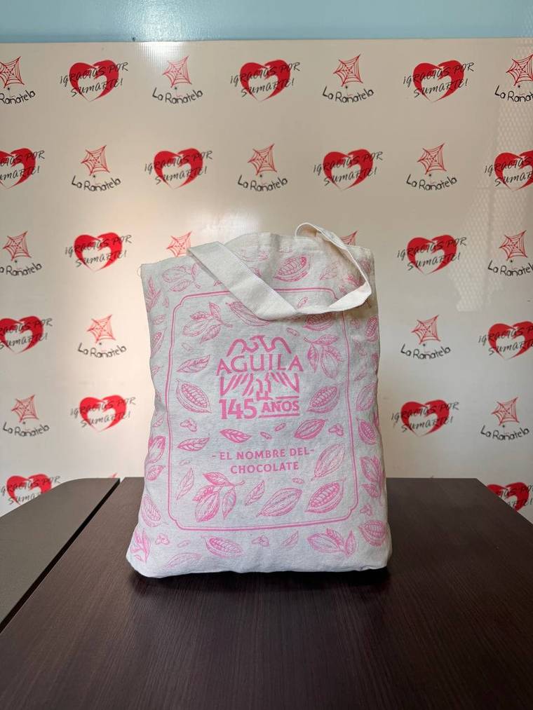 Bolsa de lienzo natural con asas del mismo material y logo impreso en el frente